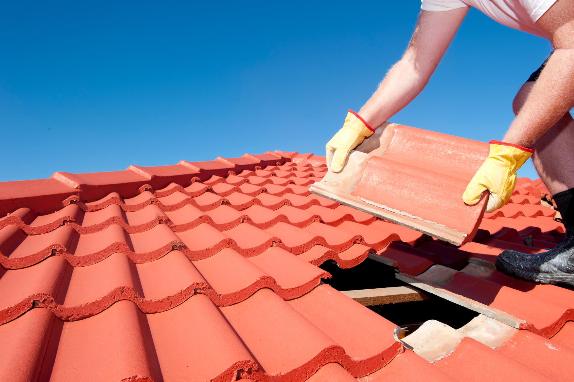 Roofing contractor placing spanish tile roof